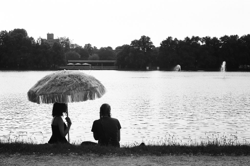 Two friends sitting under an hawaiian umbrella. Köln. Germany. 2016 © Linus Ma. all rights reserved / www.linusma.com